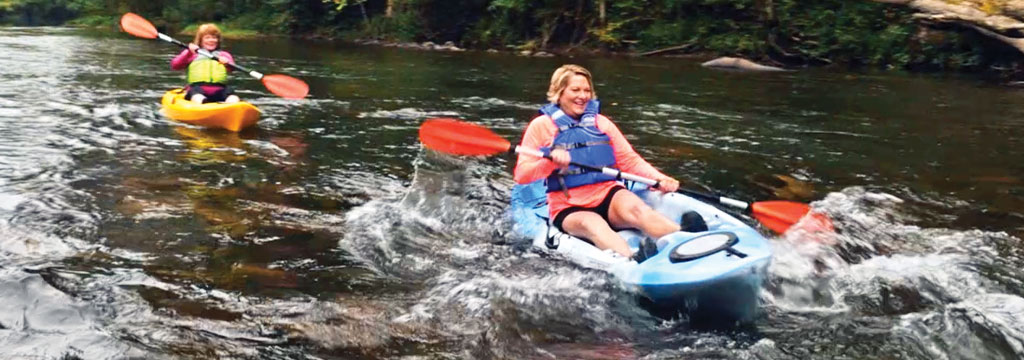 ladies kayaking through rapids